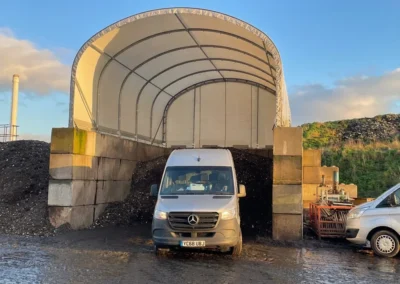 TUFFShel Lite installed on concrete blocks, creating a sheltered storage bay for bulk materials with easy vehicle access.